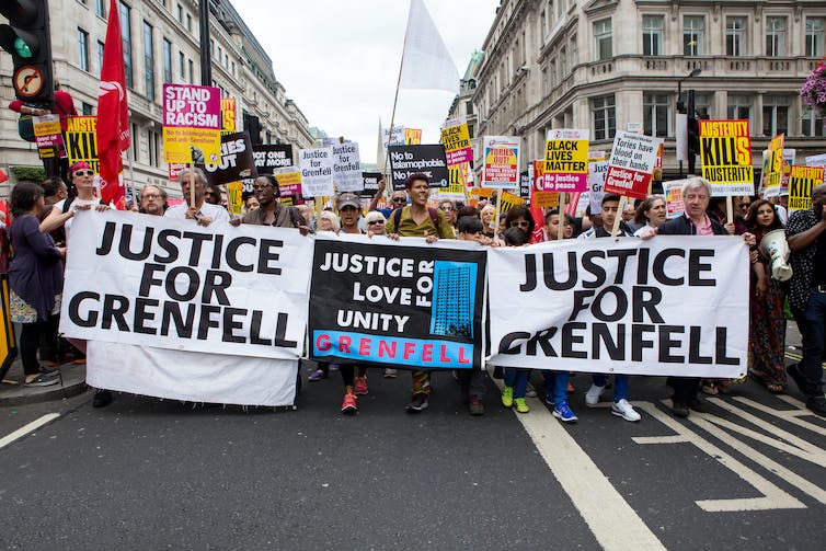 Protesters walking behind banners in a London street